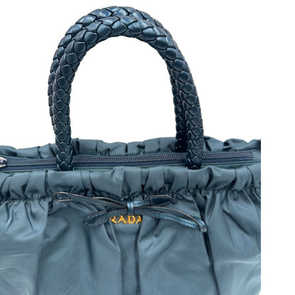manici Borsa Prada in nylon nelle tonalità del blu petrolio, munita di doppi manici in pelle intrecciati, di lusso, originale, ottime condizioni, usata.