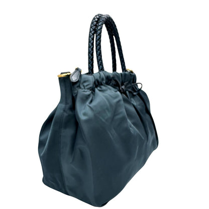 lato Borsa Prada in nylon nelle tonalità del blu petrolio, munita di doppi manici in pelle intrecciati, di lusso, originale, ottime condizioni, usata. 