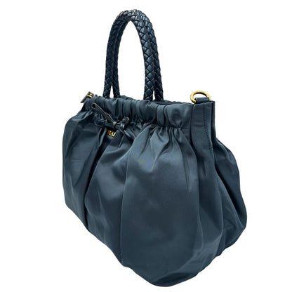 lato Borsa Prada in nylon nelle tonalità del blu petrolio, munita di doppi manici in pelle intrecciati, di lusso, originale, ottime condizioni, usata. 