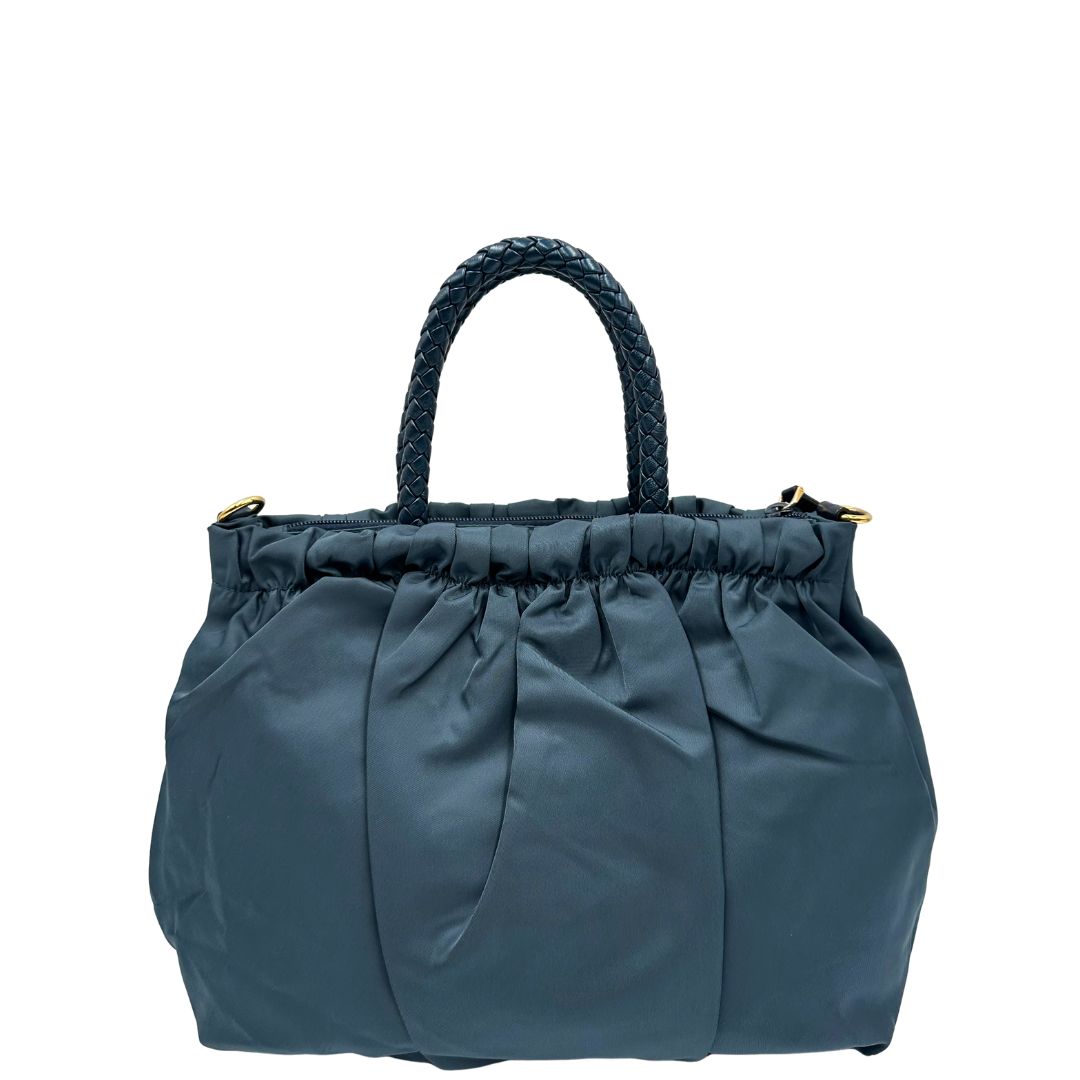 retro Borsa Prada in nylon nelle tonalità del blu petrolio, munita di doppi manici in pelle intrecciati, di lusso, originale, ottime condizioni, usata.