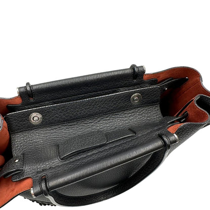 chiusura Borsa Tod's in pelle nera impreziosita da borchie tono su tono alla base, di lusso, originale, ottime condizioni, usata. 