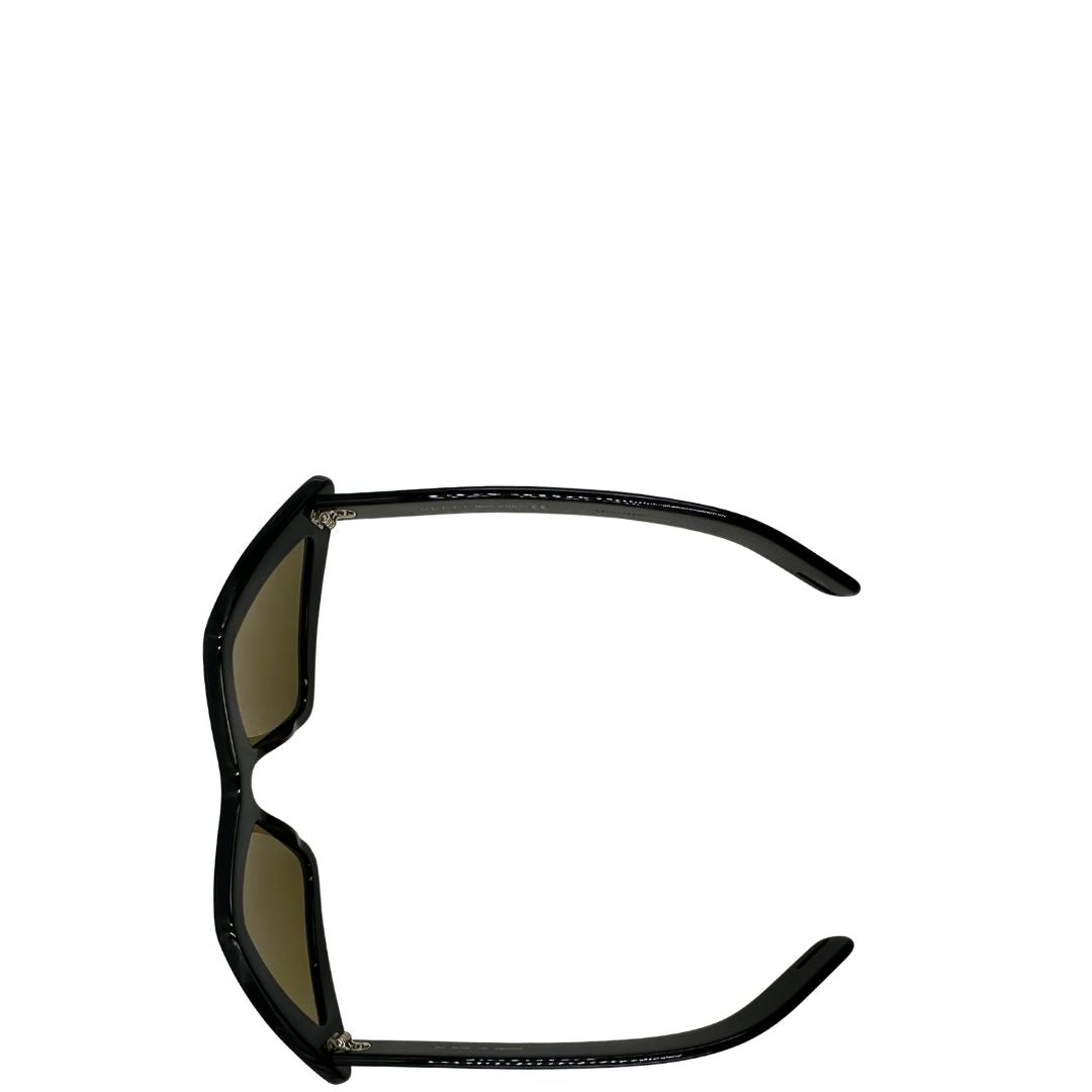 Occhiali Gucci unisex caratterizzati da una distintiva montatura geometrica a forma di diamante, realizzati in acetato nero lucido con lenti color giallo scuro.