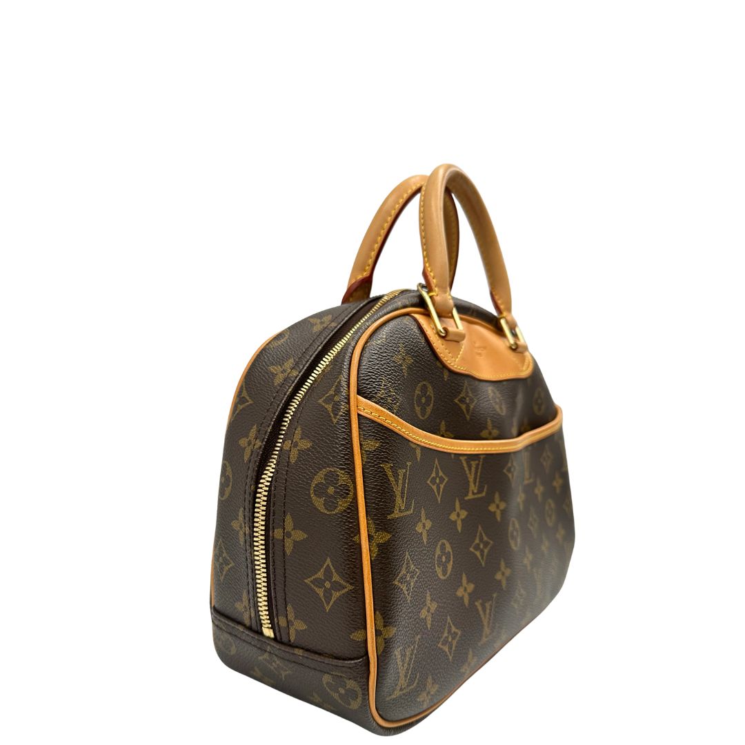 Laterale sinistro di una borsa LV Trouville in tela monogram e vacchetta naturale, usata, originale, second hand, in ottime condizioni.