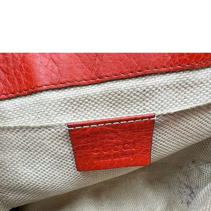 interno Borsa Gucci Soho in pelle rosso corallo impreziosita da nappa decorativa, di lusso, originale, ottime condizioni, usata.