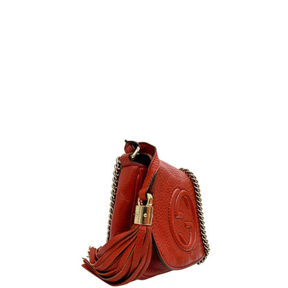 lato Borsa Gucci Soho in pelle rosso corallo impreziosita da nappa decorativa, di lusso, originale, ottime condizioni, usata. 
