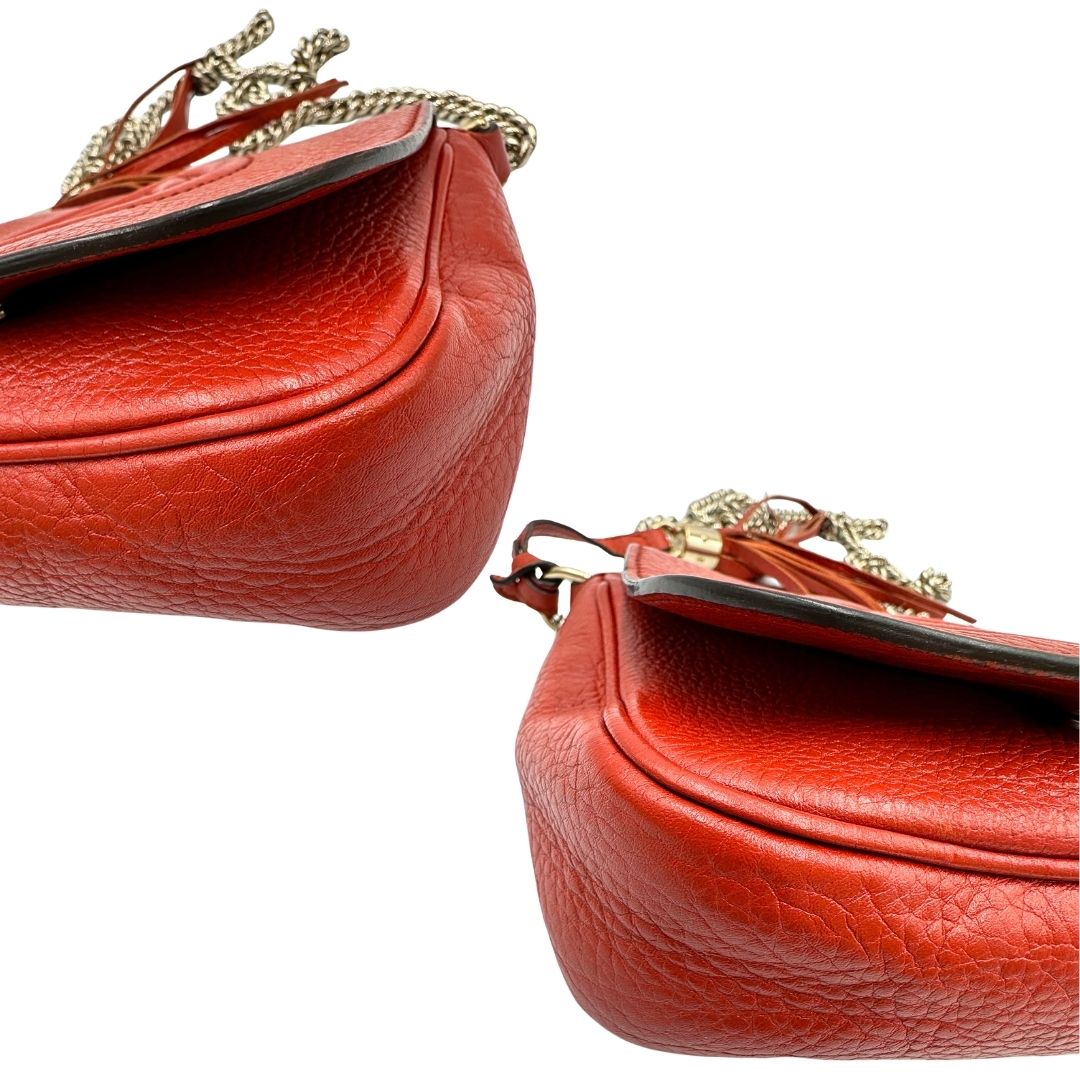 angoli Borsa Gucci Soho in pelle rosso corallo impreziosita da nappa decorativa, di lusso, originale, ottime condizioni, usata.