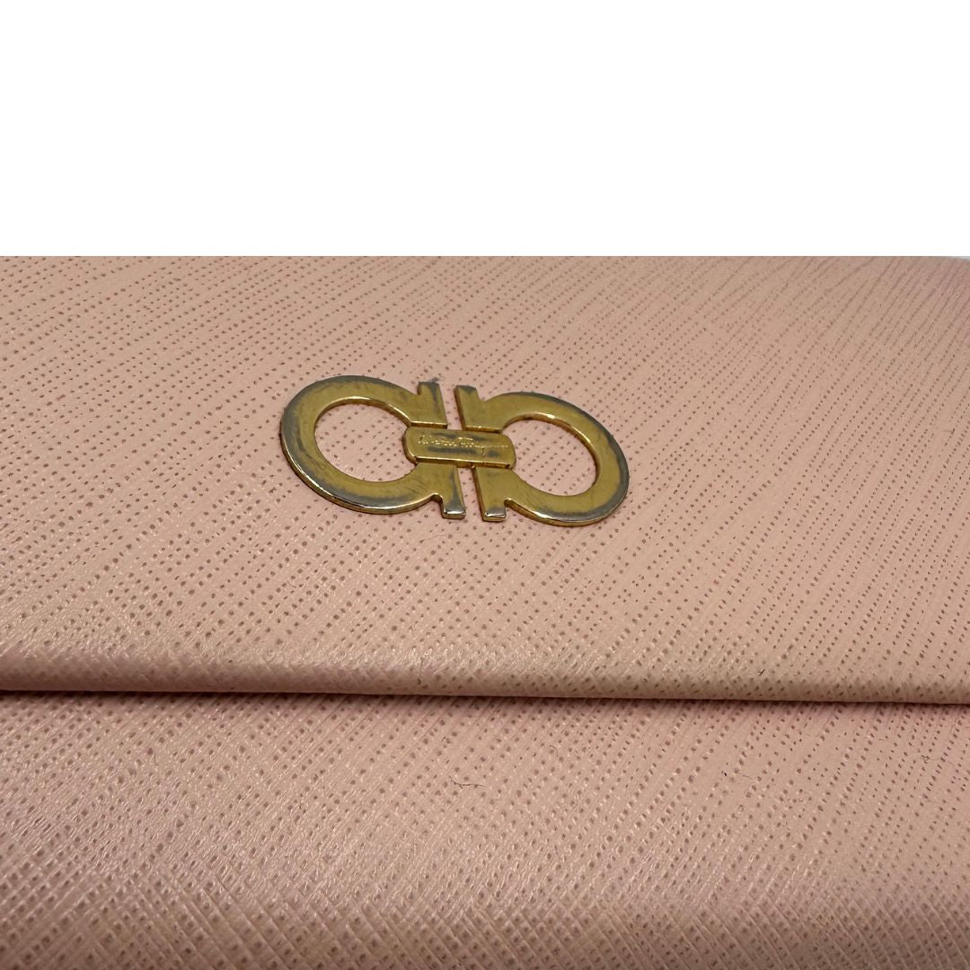 Metalleria scolorita di un portafoglio Salvatore Ferragamo in pelle rosa con metalleria oro chiaro, usato, originale, second hand, in ottime condizioni.