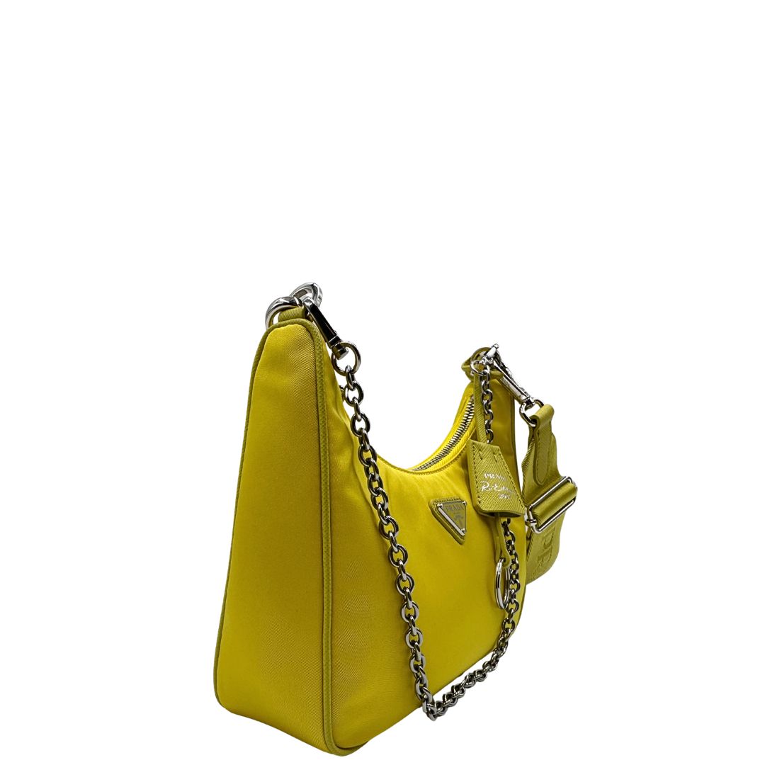 Laterale sinistro di una borsa a tracolla Prada in re-nylon giallo con pouch amovibile, usata, originale, second hand, in condizioni eccellenti.