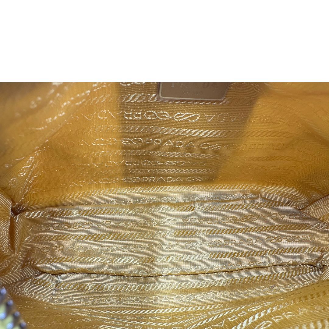 Interno di una borsa a tracolla Prada in re-nylon giallo con pouch amovibile, usata, originale, second hand, in condizioni eccellenti.