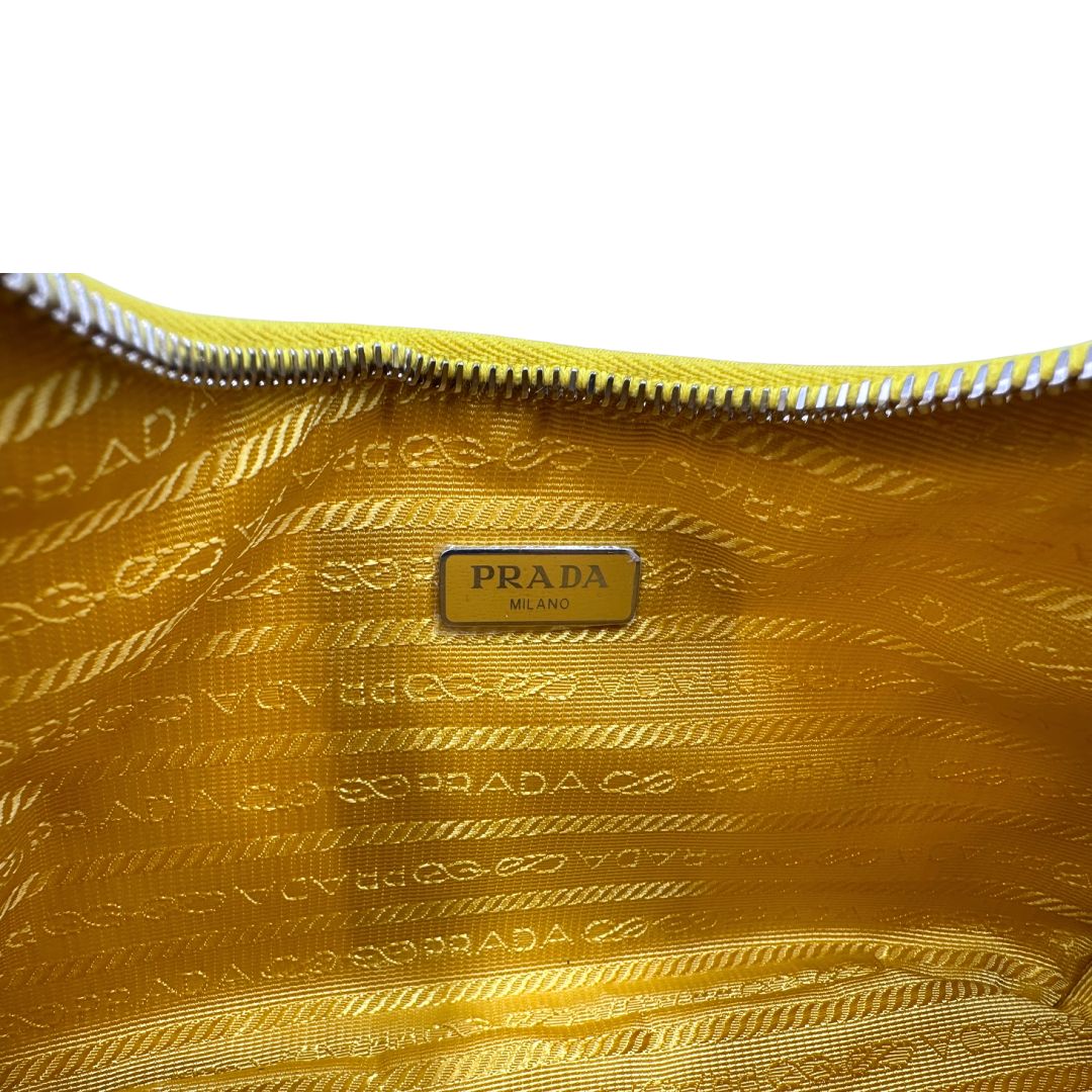 Interno di una borsa a tracolla Prada in re-nylon giallo con pouch amovibile, usata, originale, second hand, in condizioni eccellenti.