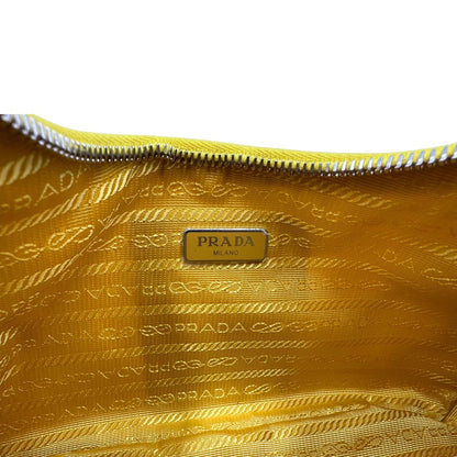 Interno di una borsa a tracolla Prada in re-nylon giallo con pouch amovibile, usata, originale, second hand, in condizioni eccellenti.