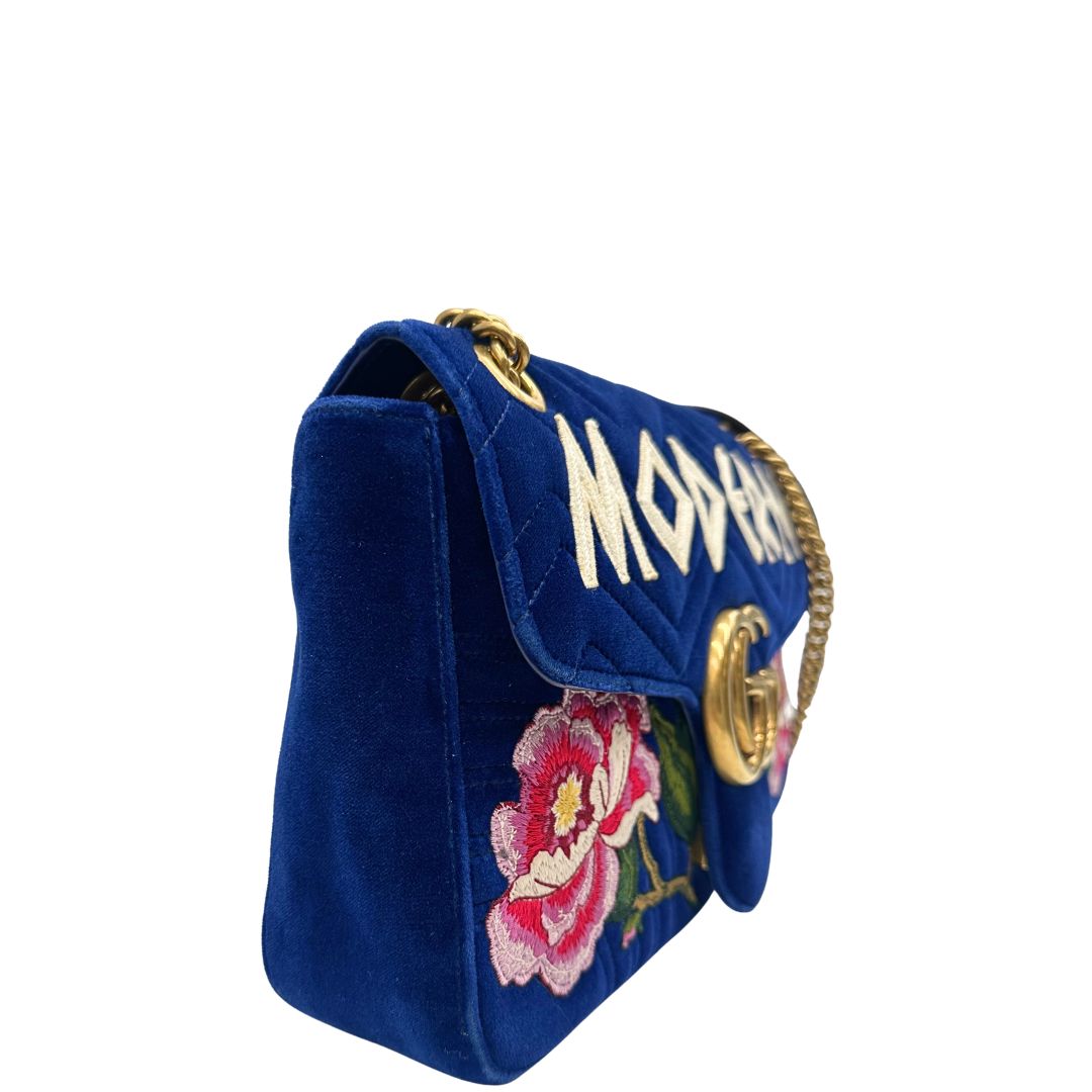 Laterale sinistro  di una borsa Gucci Marmont nella misura grande velvet color blu reale, con patchwork decorativi, usata, originale, second hand, in ottime condizioni.