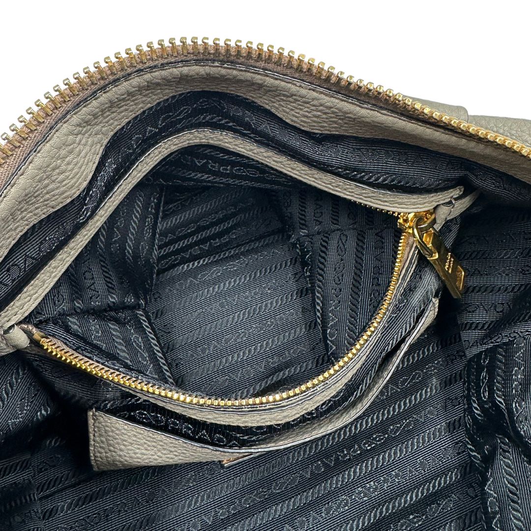 Interno, Pratica borsa Prada in pelle martellata grigia e hardware dorato, Indossabile a mano oppure a tracolla. Originale, usata, di lusso, in ottime condizioni.