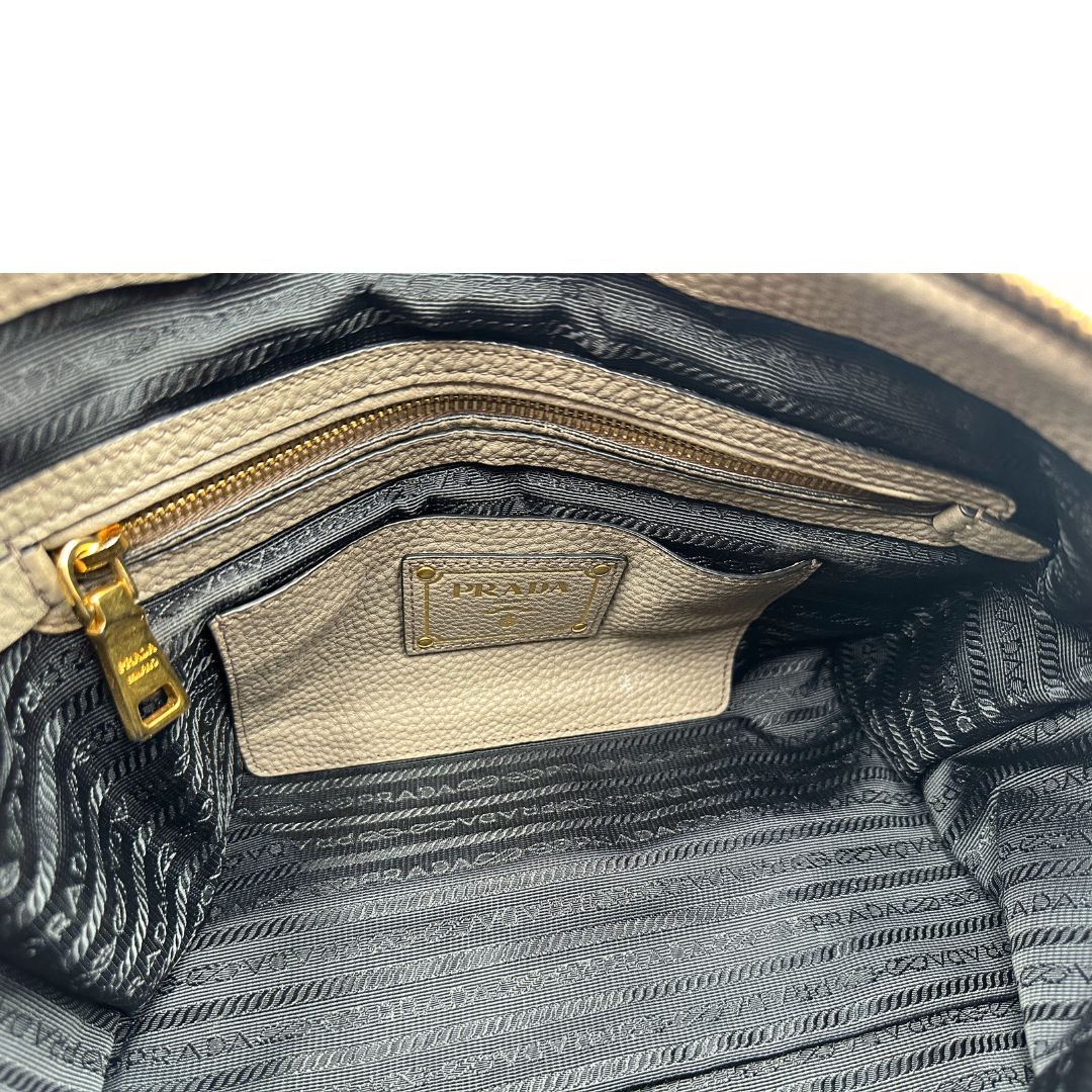 Interno, Pratica borsa Prada in pelle martellata grigia e hardware dorato, Indossabile a mano oppure a tracolla. Originale, usata, di lusso, in ottime condizioni.