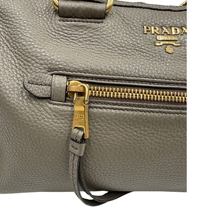 Pratica borsa Prada in pelle martellata grigia e hardware dorato, Indossabile a mano oppure a tracolla. Originale, usata, di lusso, in ottime condizioni.