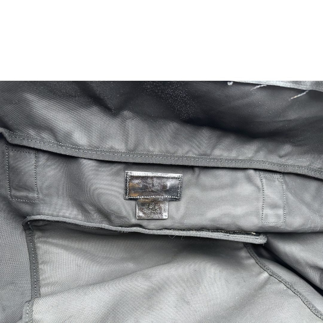 Interno di un borsone Gucci in tela nera, con dettagli in pelle tono su tono, usato, originale, second hand, in ottime condizioni.