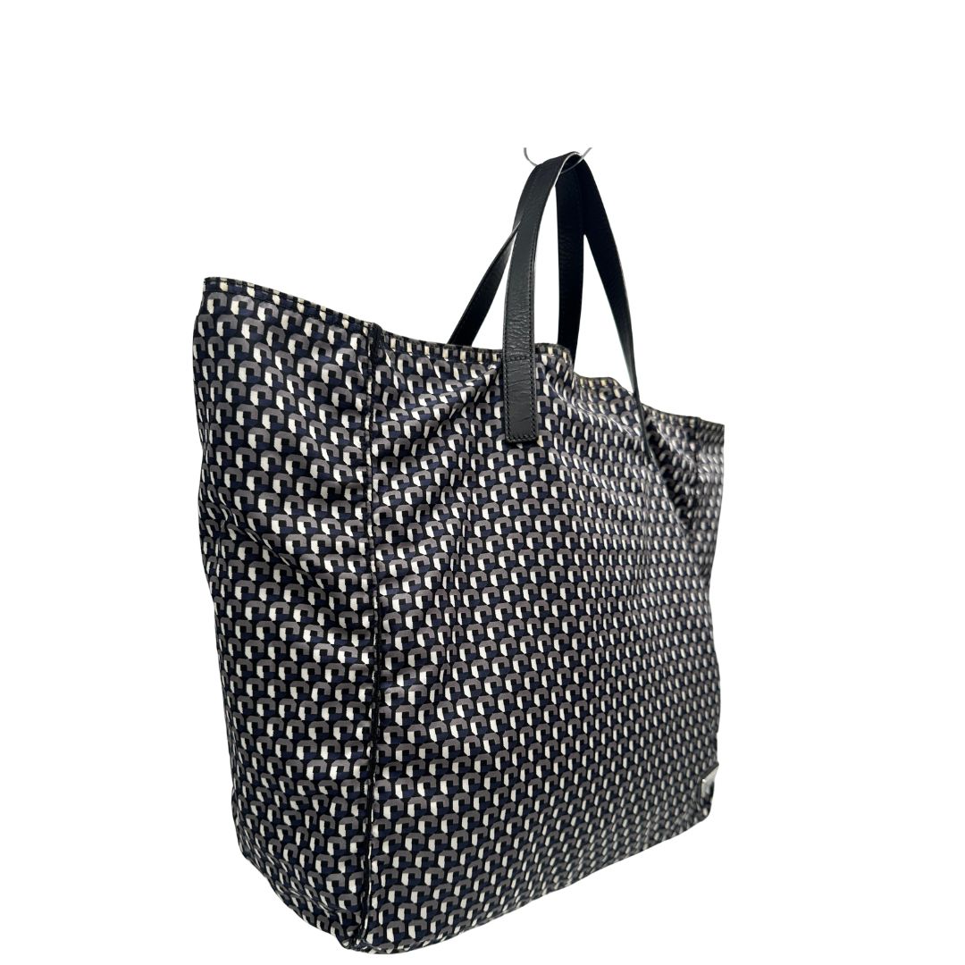 lato Borsa Prada in nylon stampato con motivo geometrico all-over nei toni del blu e bianco, arricchita da doppi manici in pelle nera, di lusso, originale, ottime condizioni, usata. 