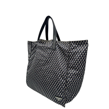 lato Borsa Prada in nylon stampato con motivo geometrico all-over nei toni del blu e bianco, arricchita da doppi manici in pelle nera, di lusso, originale, ottime condizioni, usata. 