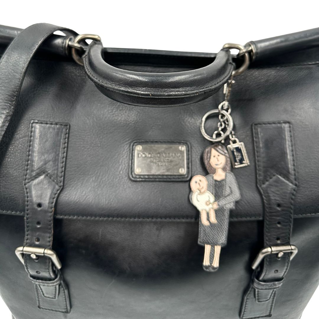 Manico, Borsa da viaggio D&G realizzata in pelle nera con hardware argentato anticato e charms decorativi. Indossabile a mano oppure a tracolla. Originale, usata, di lusso, in ottime condizioni.
