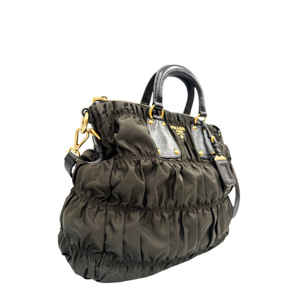 lato Borsa Prada in tessuto nylon marrone e finiture in pelle tono su tono con dettagli metallici dorati, di lusso, originale, ottime condizioni, usata. 