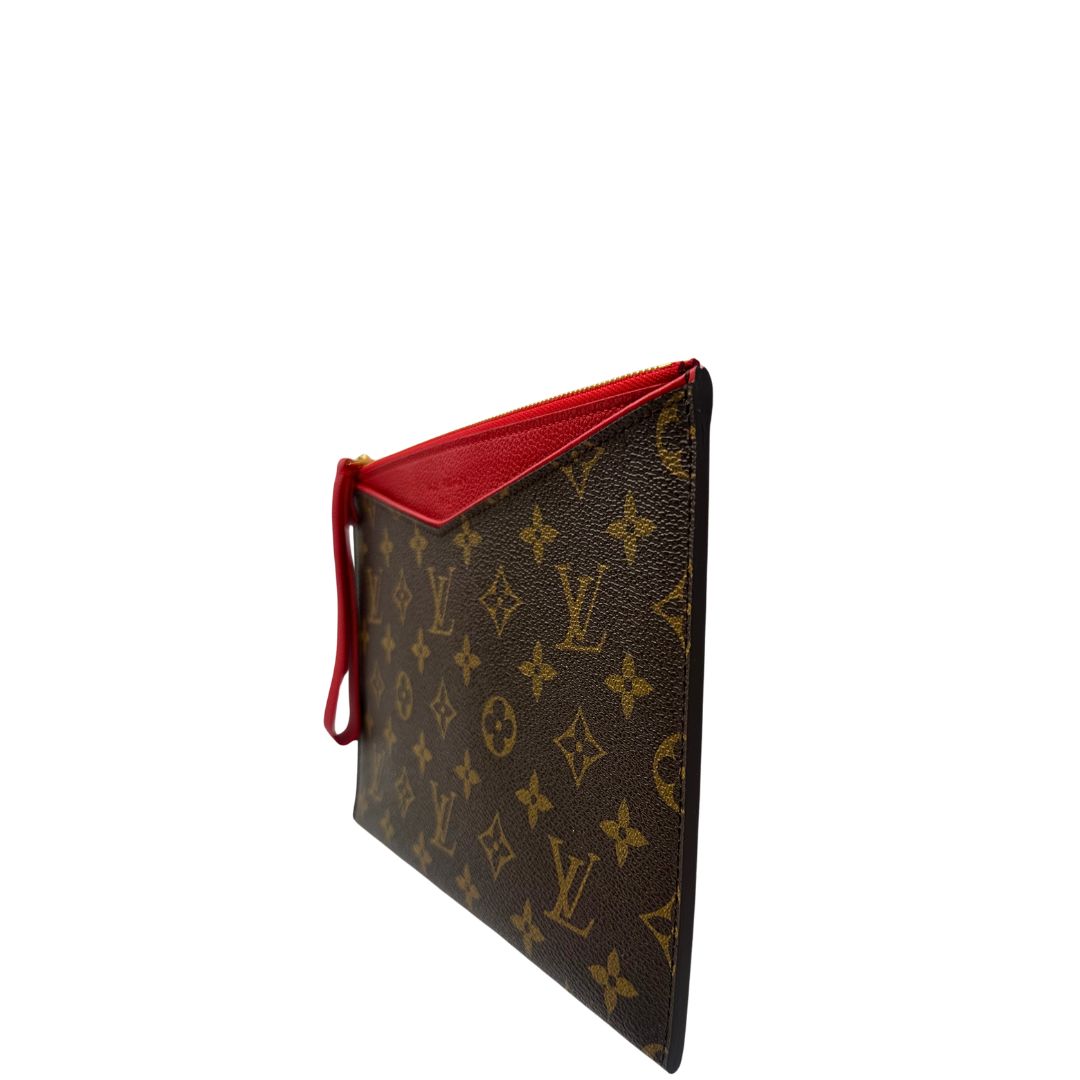 Laterale destro di una pochette Louis Vuitton con scomparti interni portacarte, in canvas marrone monogram e dettagli rossi, con parti metalliche dorate, usata, originale, second hand, in ottime condizioni.