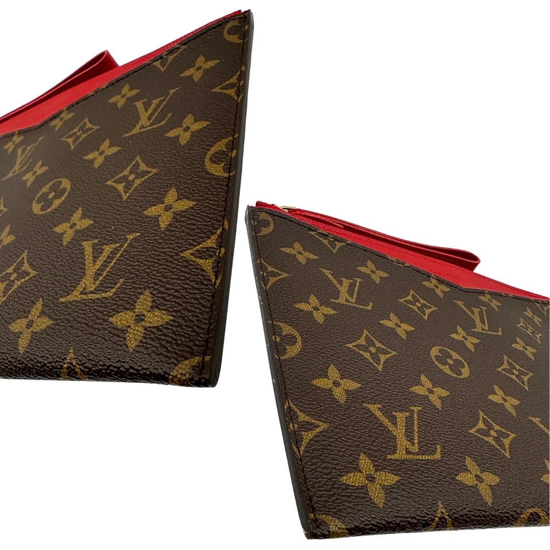Angoli di una pochette Louis Vuitton con scomparti interni portacarte, in canvas marrone monogram e dettagli rossi, con parti metalliche dorate, usata, originale, second hand, in ottime condizioni.