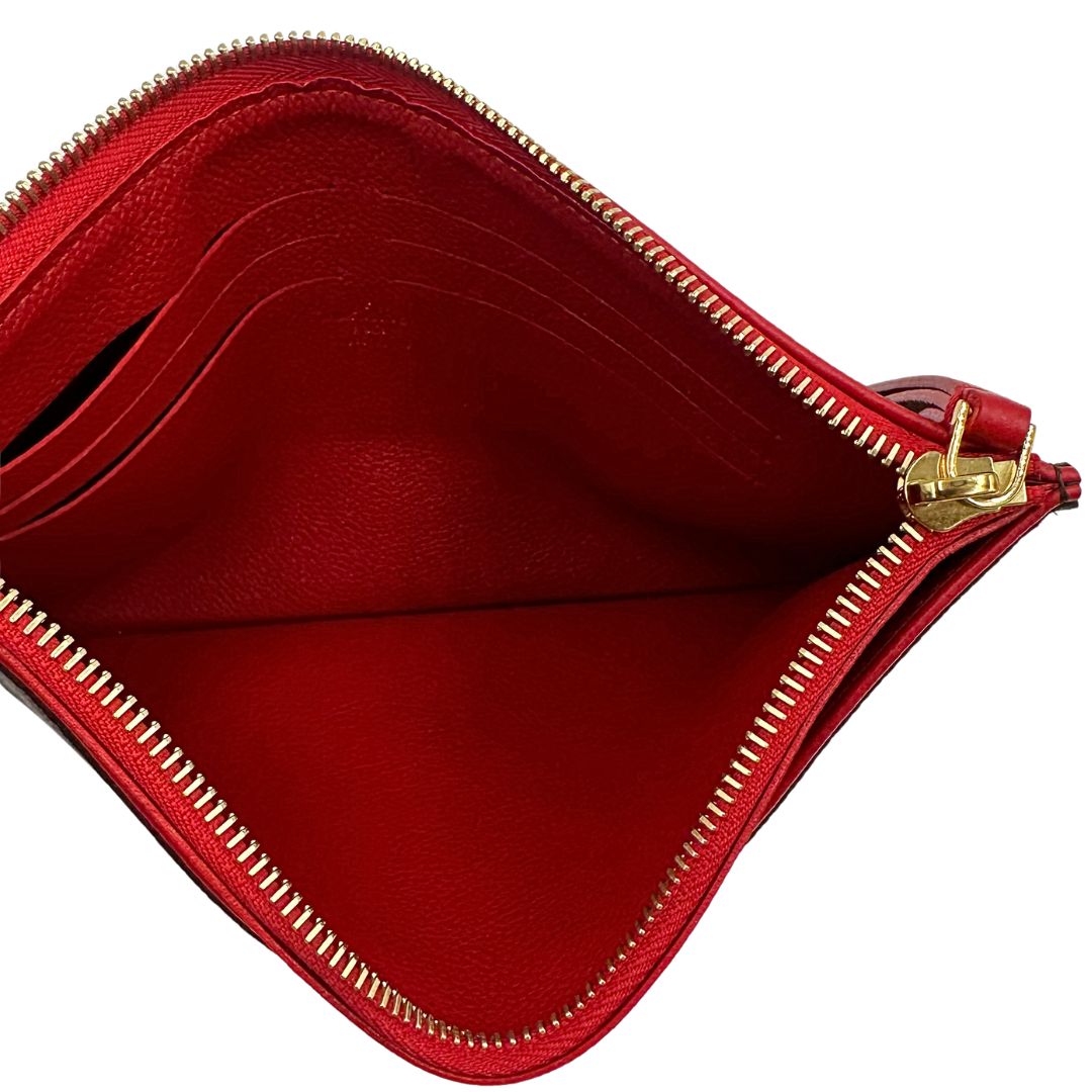 Interno di una pochette Louis Vuitton con scomparti interni portacarte, in canvas marrone monogram e dettagli rossi, con parti metalliche dorate, usata, originale, second hand, in ottime condizioni.