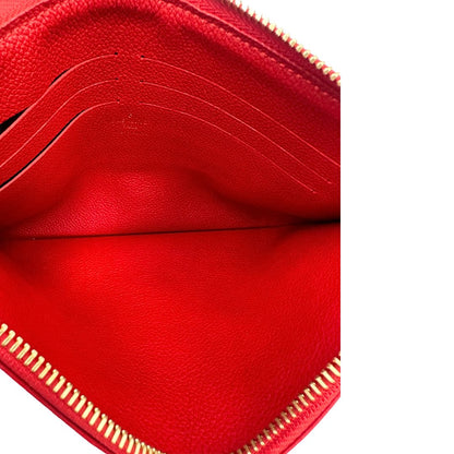 Interno di una pochette Louis Vuitton con scomparti interni portacarte, in canvas marrone monogram e dettagli rossi, con parti metalliche dorate, usata, originale, second hand, in ottime condizioni.