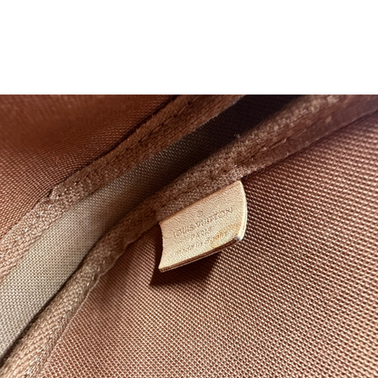 Etichetta di una Multi Pochette Accessoires Louis Vuitton in canvas marrone monogram con dettagli in vacchetta naturale, manico in catena dorata e tracolla in tessuto Jacquard rosa, usata, originale, second hand, in ottime condizioni.
