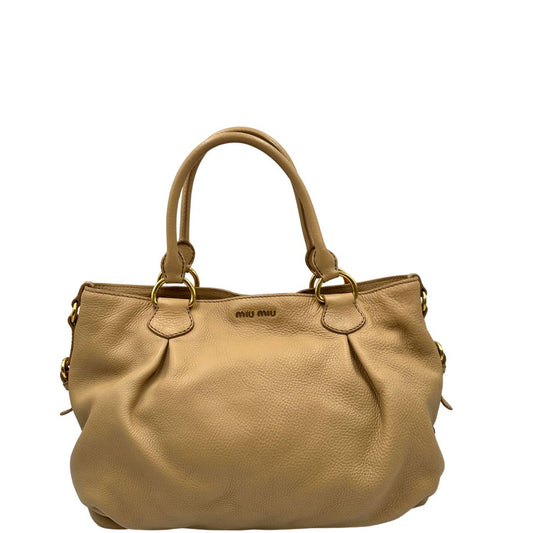 Front, Pratica borsa Miu Miu in pelle martellata beige con parti metalliche dorate. Indossabile a spalla oppure a mano. Originale, usata, di lusso, in ottime condizioni.