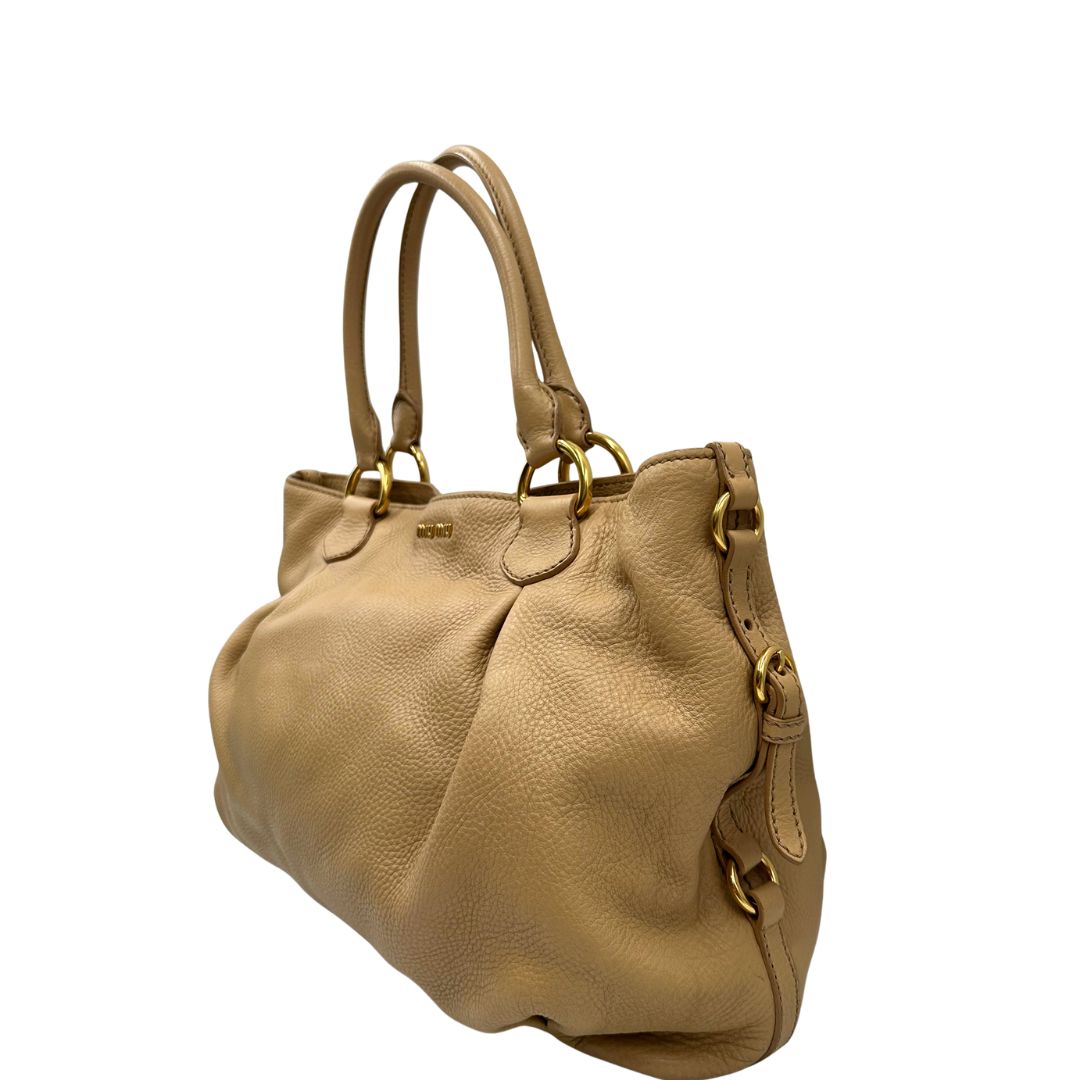 Laterale, Pratica borsa Miu Miu in pelle martellata beige con parti metalliche dorate. Indossabile a spalla oppure a mano. Originale, usata, di lusso, in ottime condizioni.