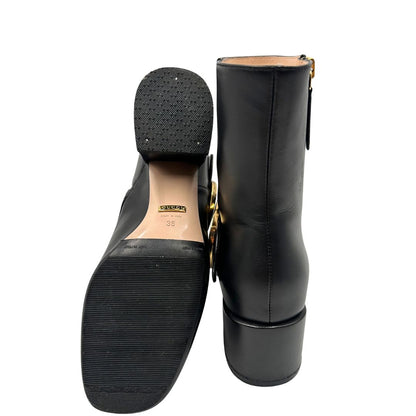 Base di un paio di stivaletti Gucci in pelle nera, con iconico dettaglio Soho in metallo dorato, usati, originali, second hand, in ottime condizioni.