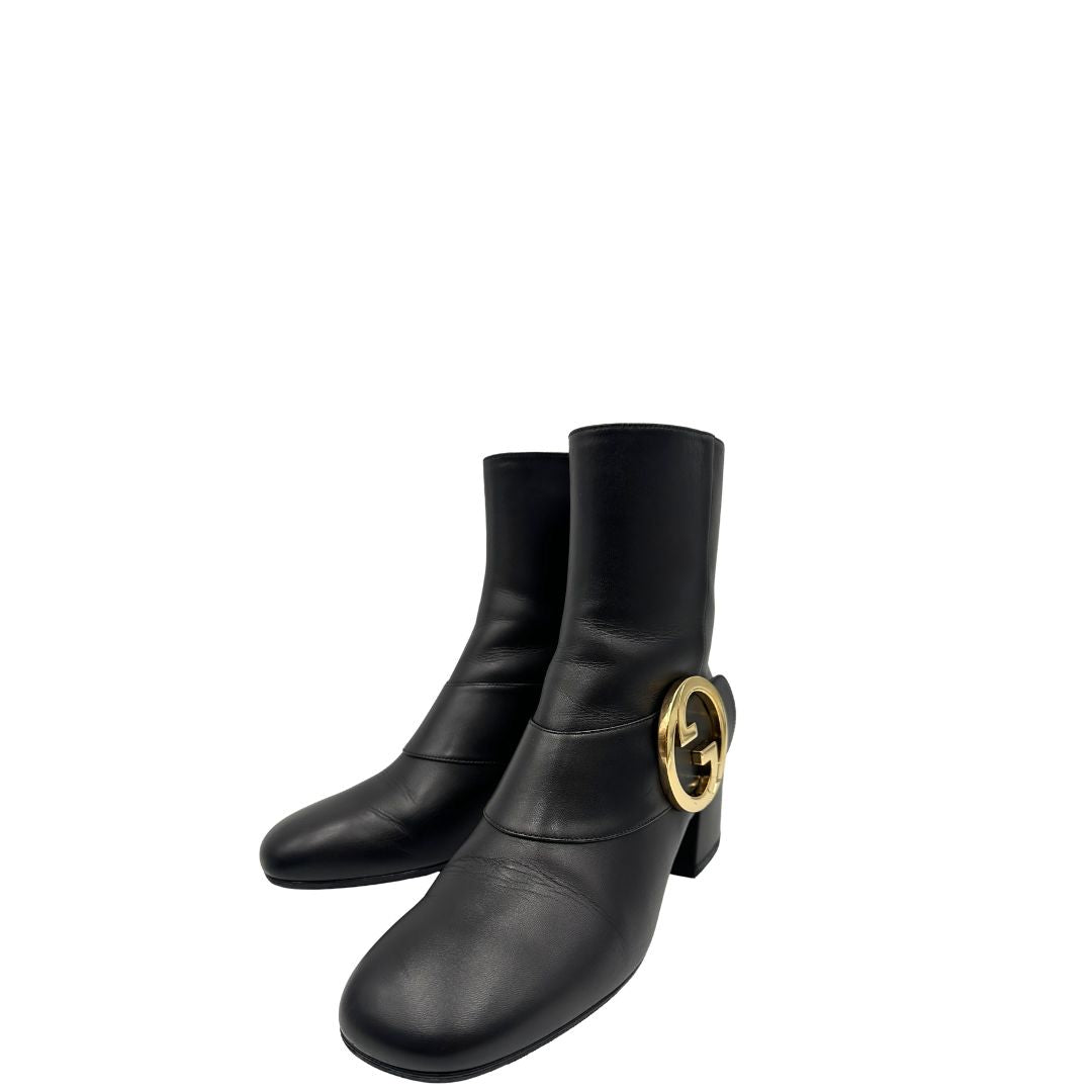 Front di un paio di stivaletti Gucci in pelle nera, con iconico dettaglio Soho in metallo dorato, usati, originali, second hand, in ottime condizioni.