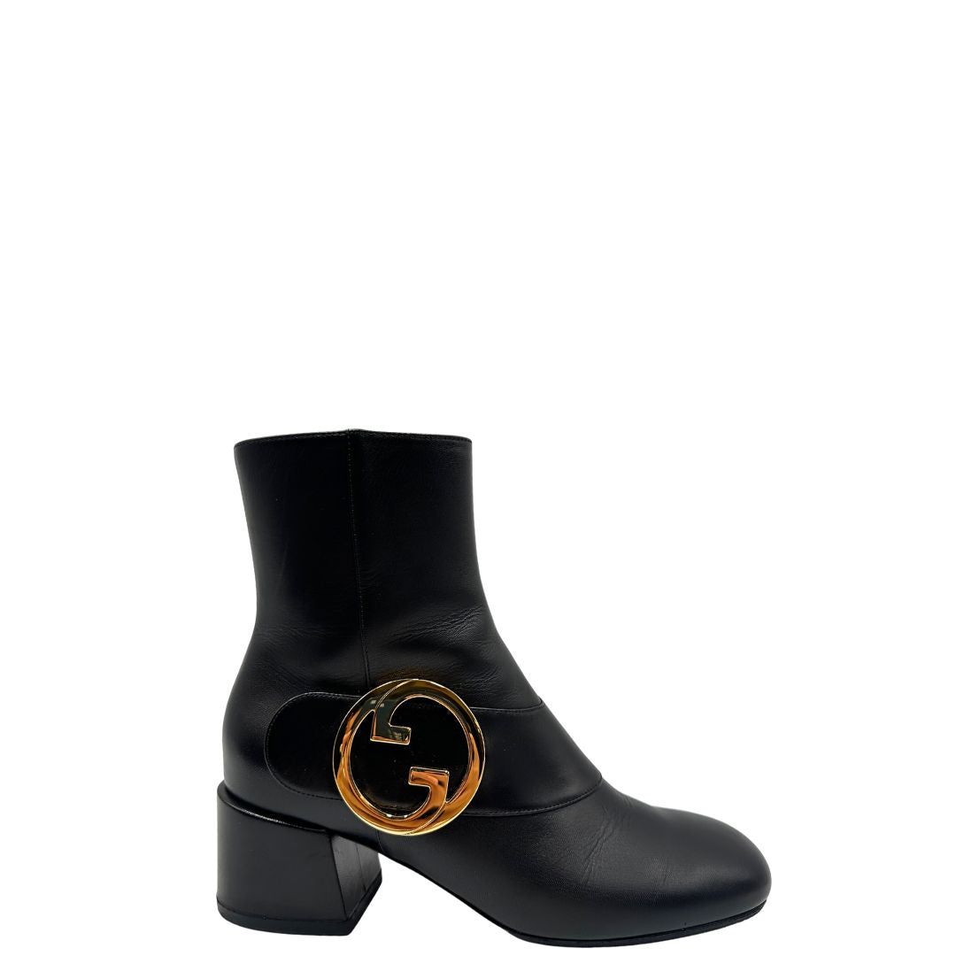 Laterale di un paio di stivaletti Gucci in pelle nera, con iconico dettaglio Soho in metallo dorato, usati, originali, second hand, in ottime condizioni.