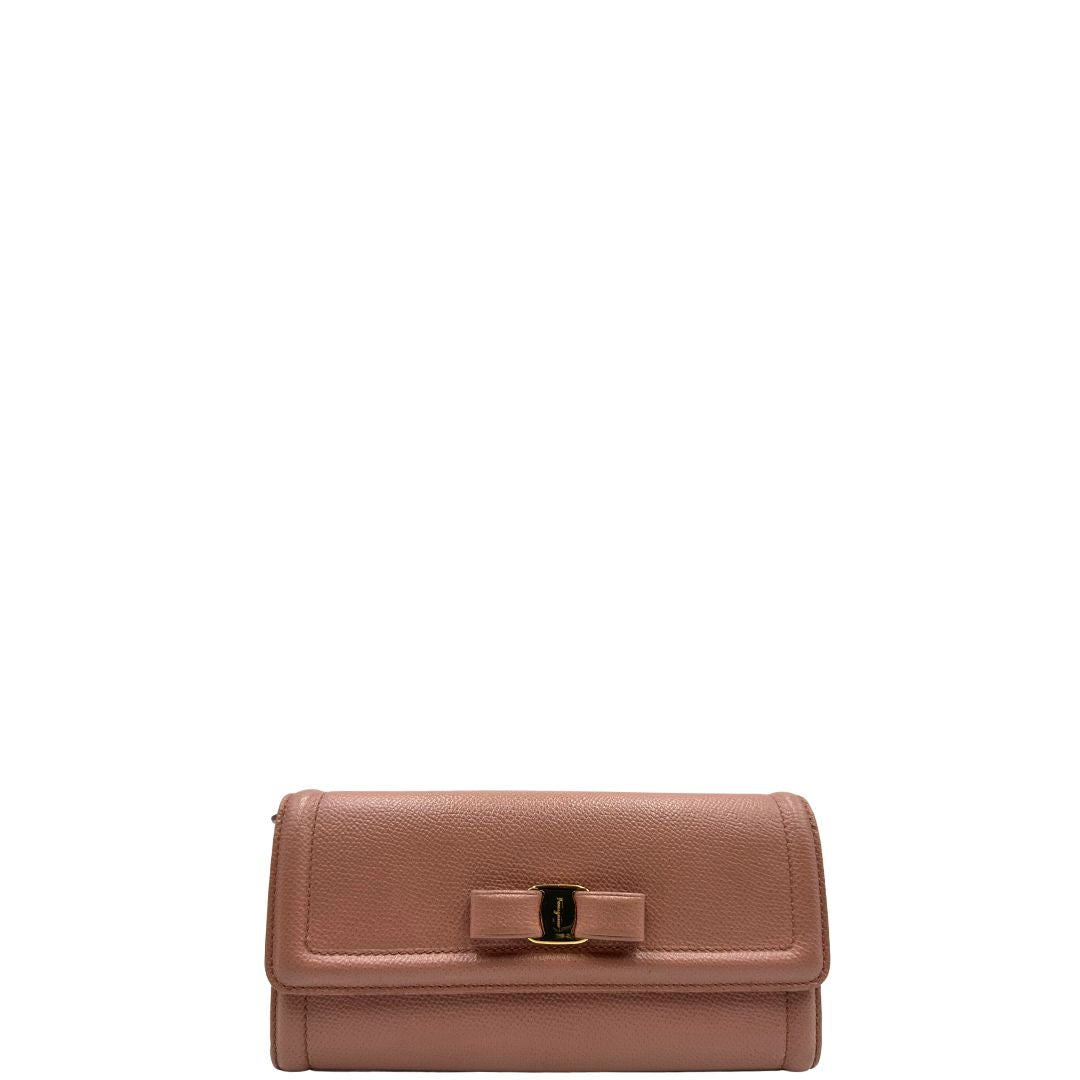 Front di un portafoglio Ferragamo in pelle rosa, dotata di un porta tessera estraibile. Iconico fiocco del brand sul front, usato, originale, second hand, in buone condizioni.