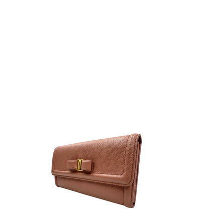 Laterale destro di un portafoglio Ferragamo in pelle rosa, dotata di un porta tessera estraibile. Iconico fiocco del brand sul front, usato, originale, second hand, in buone condizioni.