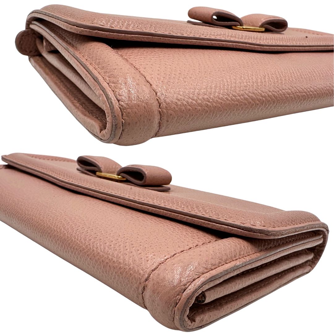 Angoli di un portafoglio Ferragamo in pelle rosa, dotata di un porta tessera estraibile. Iconico fiocco del brand sul front, usato, originale, second hand, in buone condizioni.