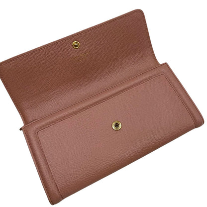 Apertura di un portafoglio Ferragamo in pelle rosa, dotata di un porta tessera estraibile. Iconico fiocco del brand sul front, usato, originale, second hand, in buone condizioni.
