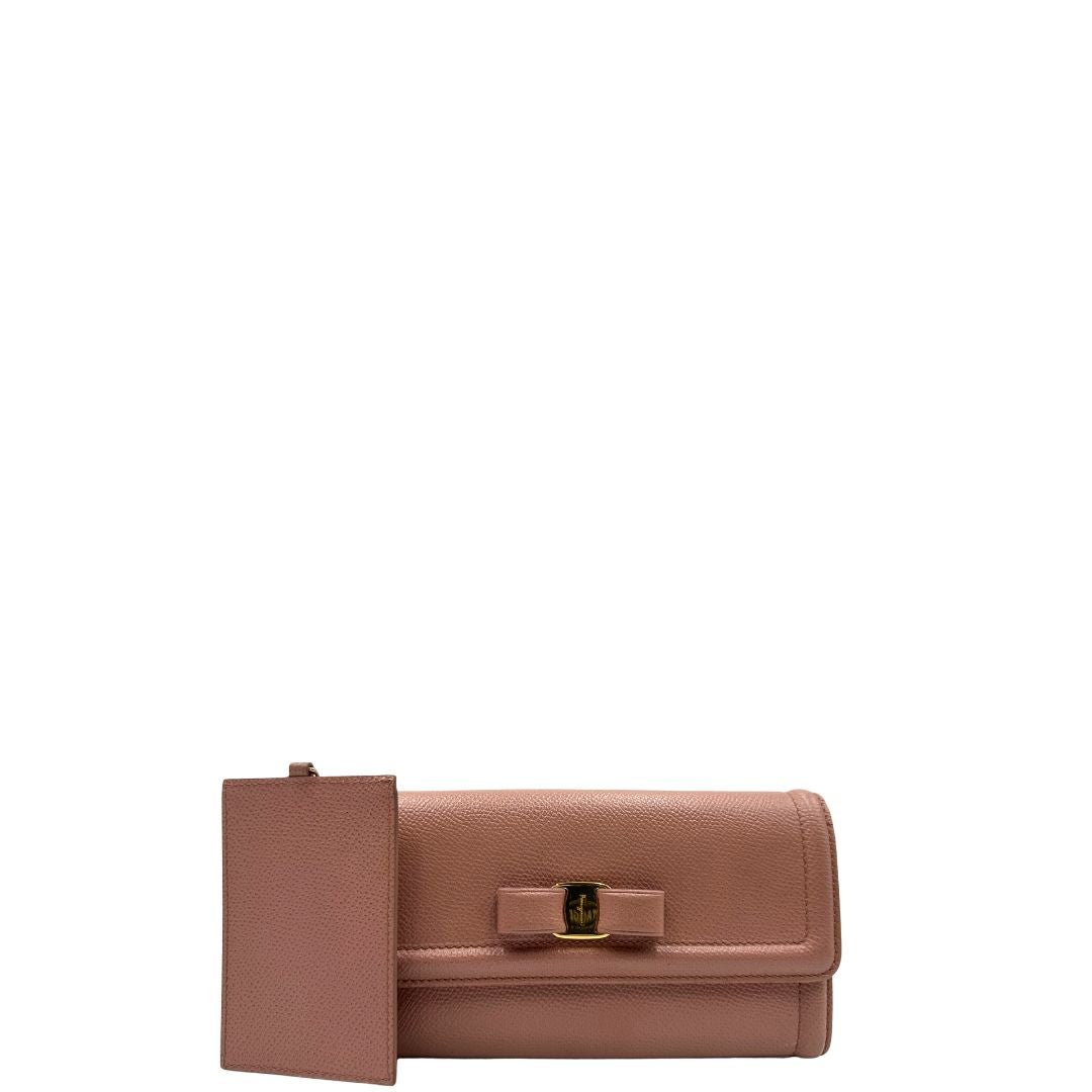 Front di un portafoglio Ferragamo in pelle rosa, dotata di un porta tessera estraibile. Iconico fiocco del brand sul front, usato, originale, second hand, in buone condizioni.