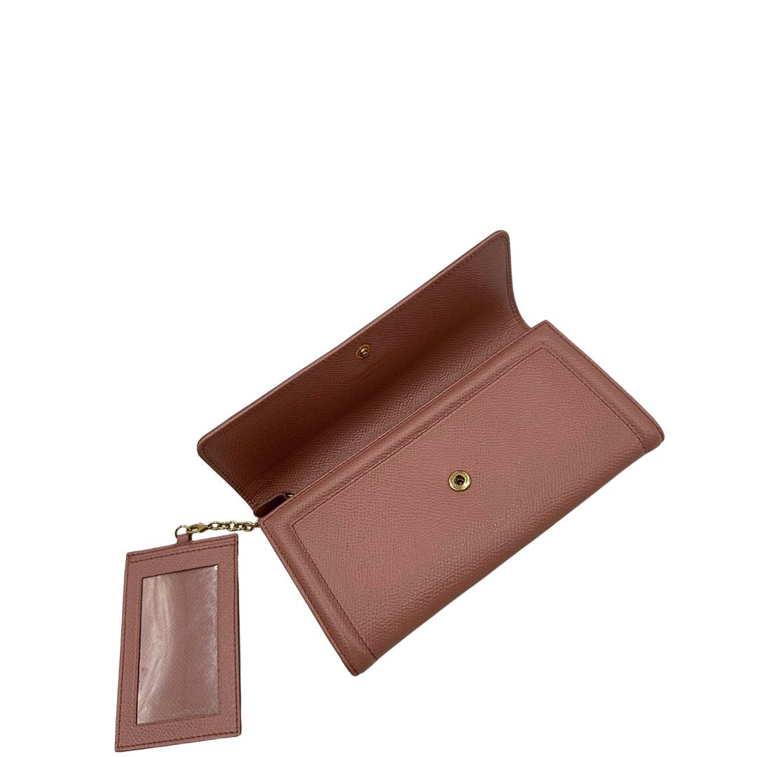 Apertura di un portafoglio Ferragamo in pelle rosa, dotata di un porta tessera estraibile. Iconico fiocco del brand sul front, usato, originale, second hand, in buone condizioni.