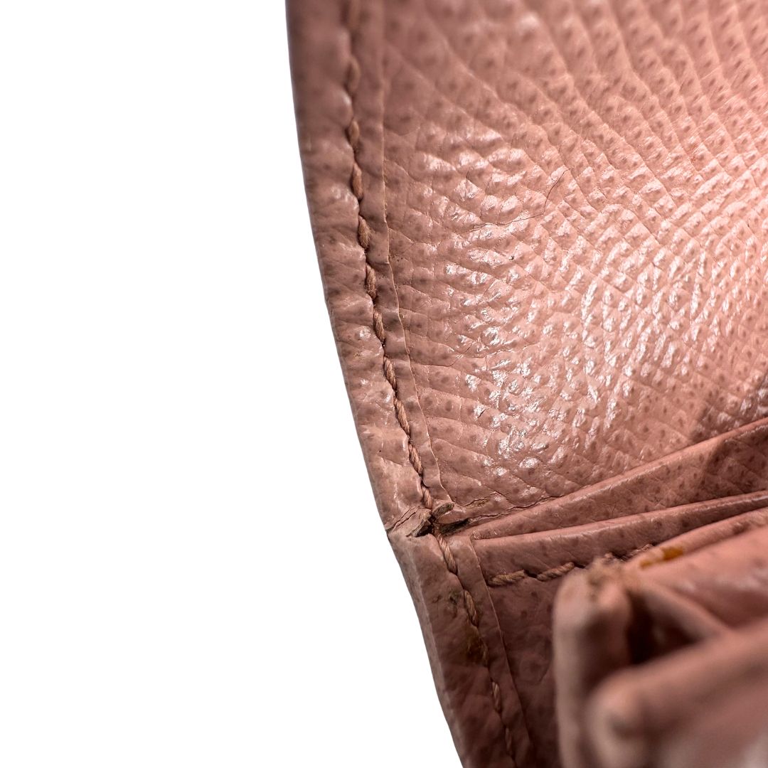 Difetto di un portafoglio Ferragamo in pelle rosa, dotata di un porta tessera estraibile. Iconico fiocco del brand sul front, usato, originale, second hand, in buone condizioni.