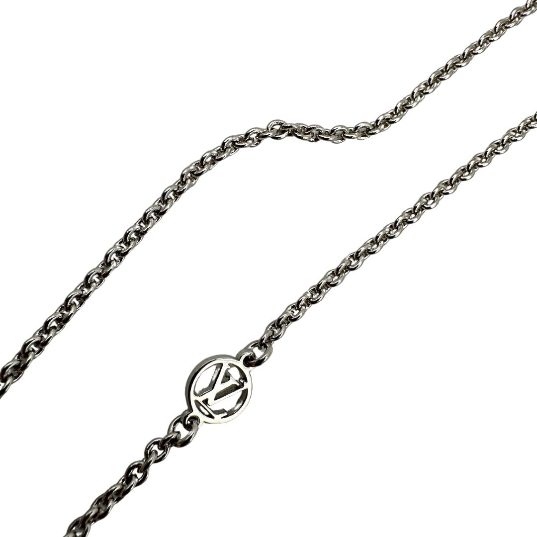 Collana Essential V Supple Louis Vuitton in metallo con finitura argentata lucida, impreziosita dal ciondolo con l'emblematica iniziale della Maison. Completata dall'iconico logo LV Circle, che impreziosisce la catenella e la chiusura con moschettone. Originale, di lusso, usata, in condizioni ottime. 