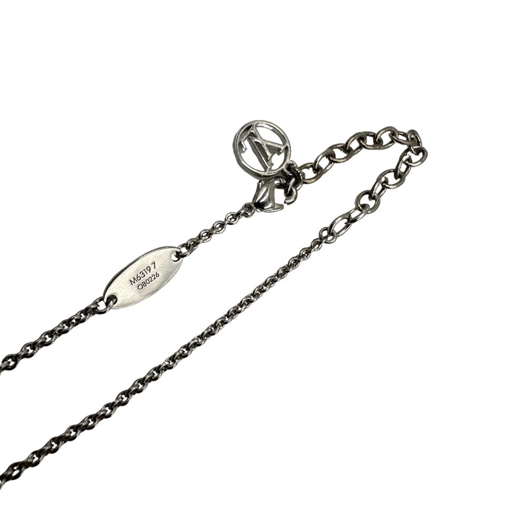 Collana Essential V Supple Louis Vuitton in metallo con finitura argentata lucida, impreziosita dal ciondolo con l'emblematica iniziale della Maison. Completata dall'iconico logo LV Circle, che impreziosisce la catenella e la chiusura con moschettone. Originale, di lusso, usata, in condizioni ottime. 