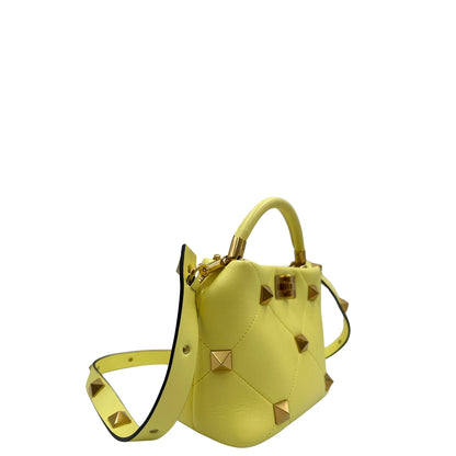 Lato, Borsa V. G. in nappa gialla, caratterizzata da un'impuntura a rombi trapuntata, maxi borchie iconiche e dettagli metallici color oro. Indossabile a mano oppure a tracolla. Originale, usata, di lusso, in ottime condizioni.