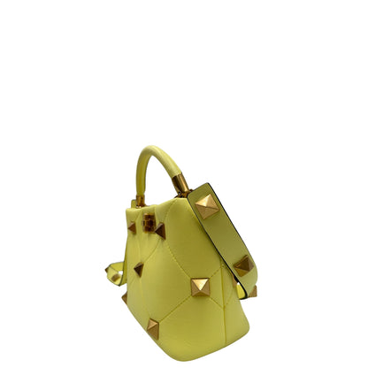 Lato, Borsa V. G. in nappa gialla, caratterizzata da un'impuntura a rombi trapuntata, maxi borchie iconiche e dettagli metallici color oro. Indossabile a mano oppure a tracolla. Originale, usata, di lusso, in ottime condizioni.