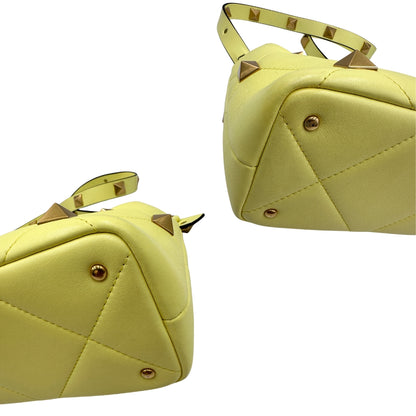 Angoli, Borsa V. G. in nappa gialla, caratterizzata da un'impuntura a rombi trapuntata, maxi borchie iconiche e dettagli metallici color oro. Indossabile a mano oppure a tracolla. Originale, usata, di lusso, in ottime condizioni.