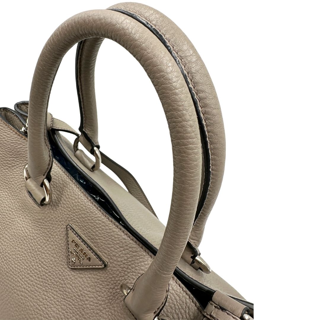 manici Borsa Tote Prada in pelle grigia con hardware argentato, munita di doppi manici e una tracolla amovibile e regolabile