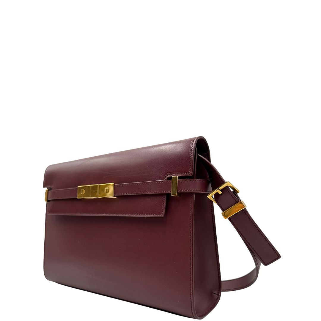Borsa Saint Laurent Manhattan in pelle bordeaux e hardware dorato, da portare a spalla.