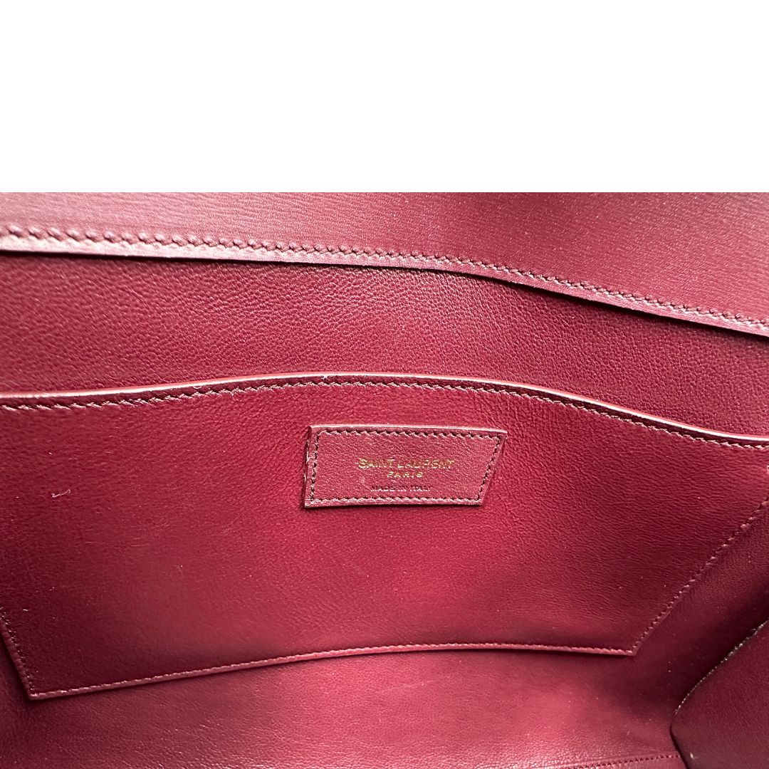 Borsa Saint Laurent Manhattan in pelle bordeaux e hardware dorato, da portare a spalla.