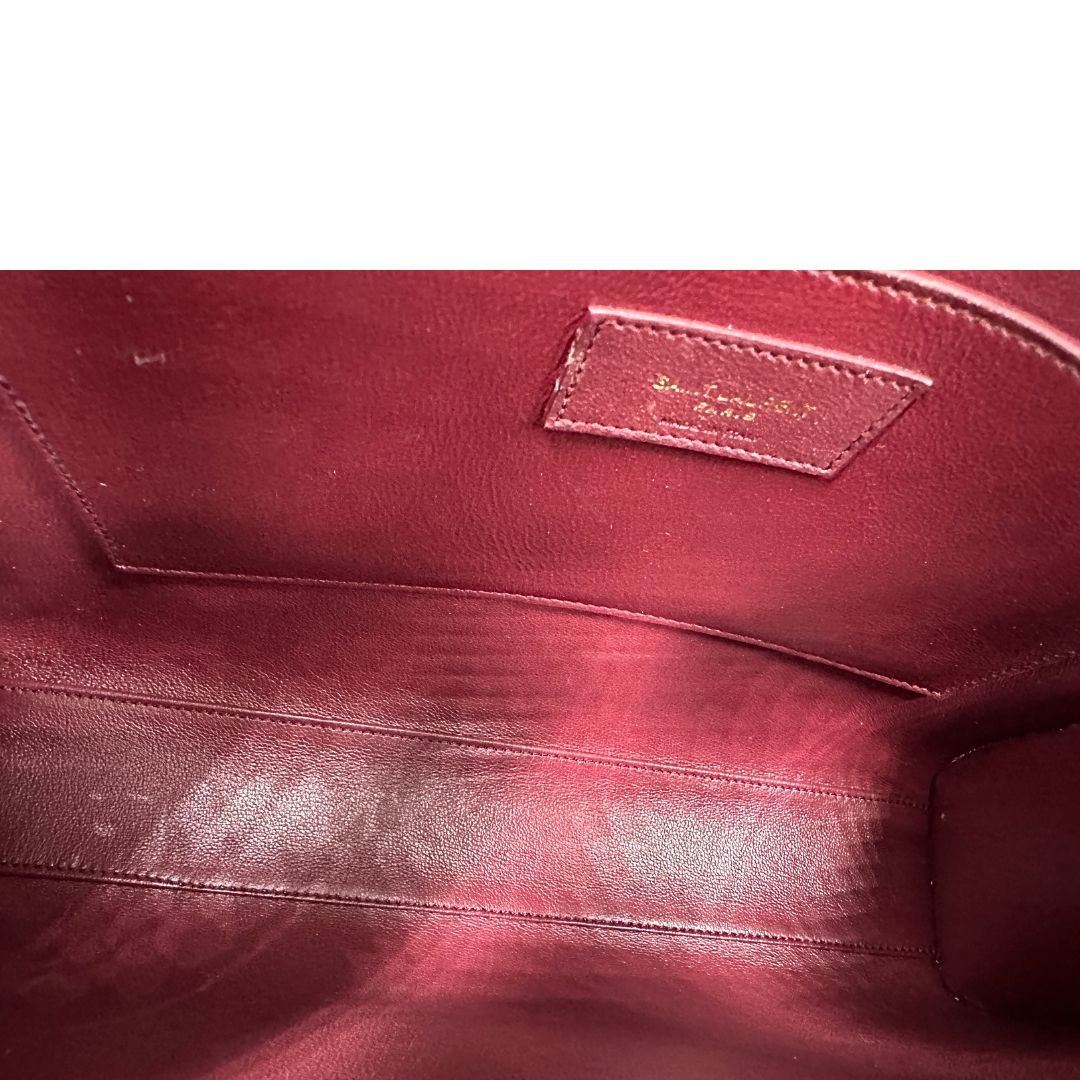 Borsa Saint Laurent Manhattan in pelle bordeaux e hardware dorato, da portare a spalla.